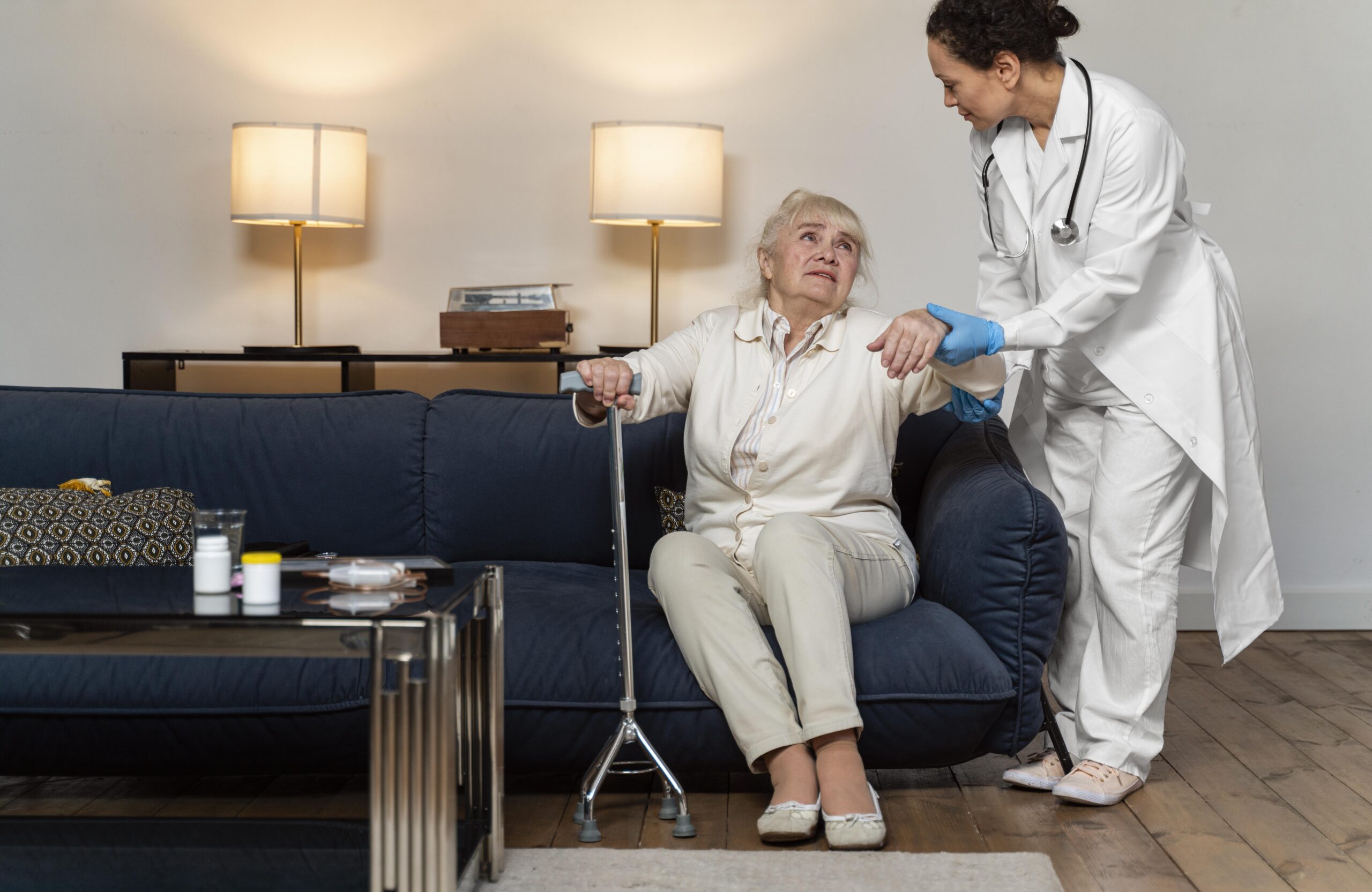 doctor helping her old patient stand up